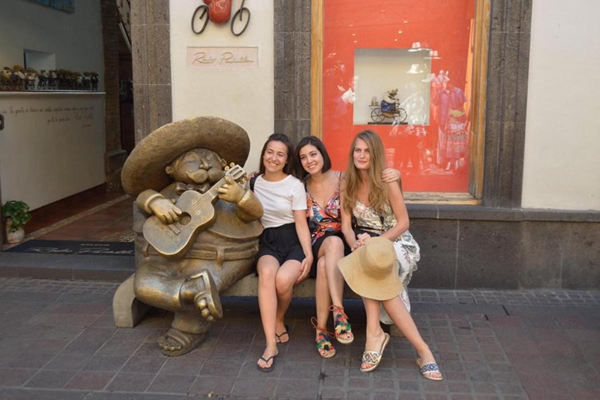 Tres niñas sentadas en una estatua de un oso