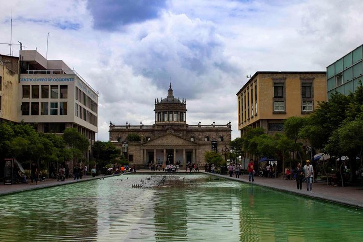 Una fuente en medio de una ciudad con un edificio.