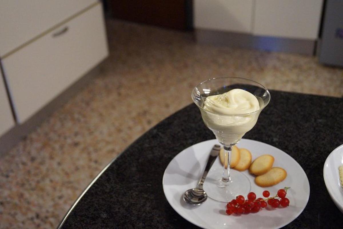 a glass of ice cream and berries on a table