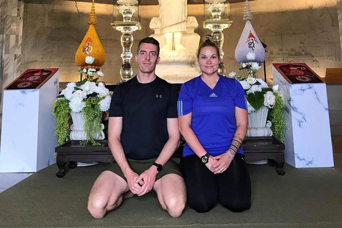 un uomo e una donna seduti sul pavimento in un tempio