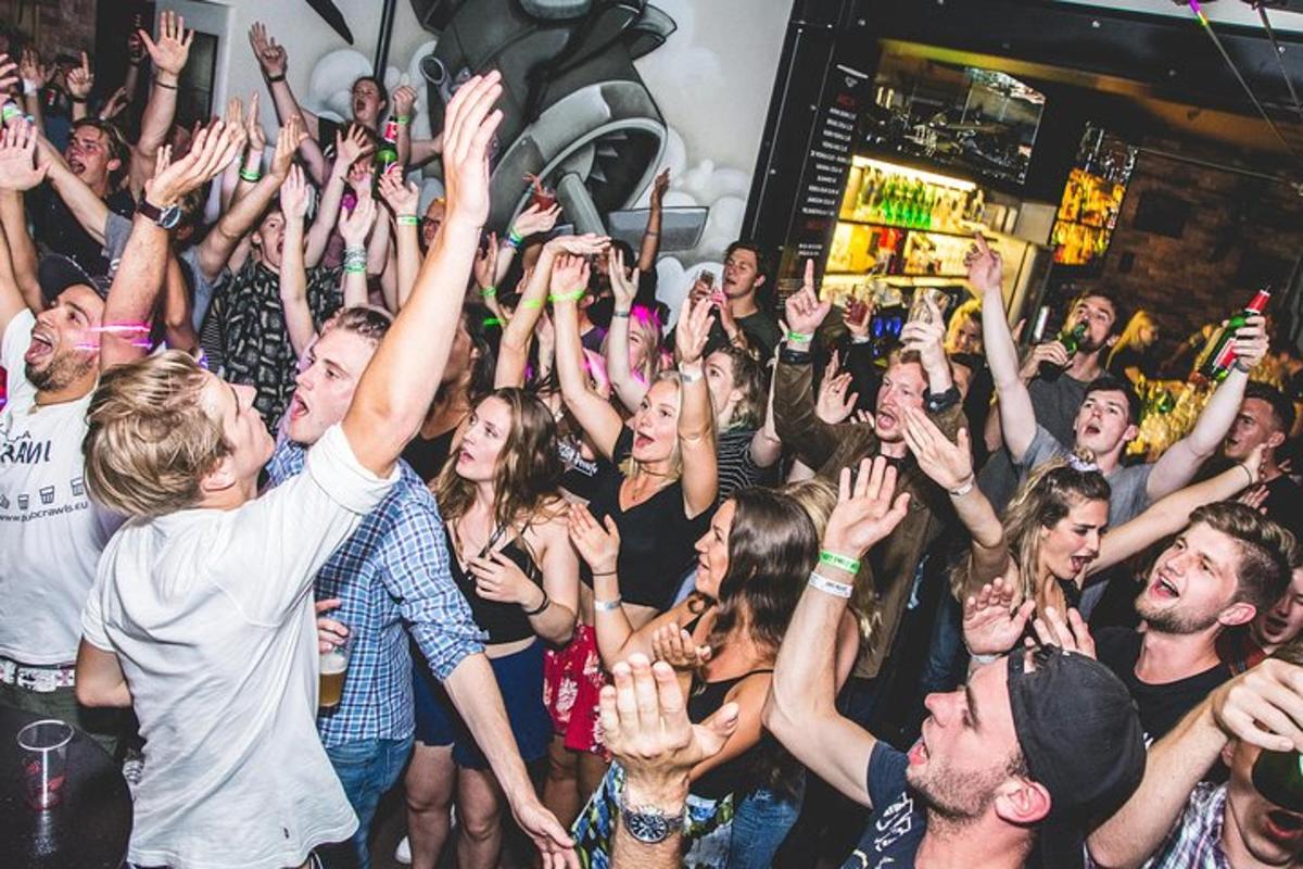 a crowd of people raising their hands at a party