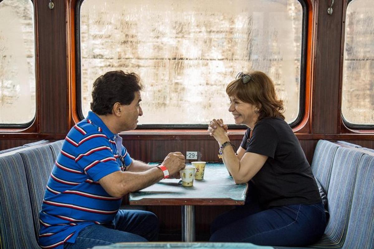 un uomo e una donna seduti a un tavolo su un treno