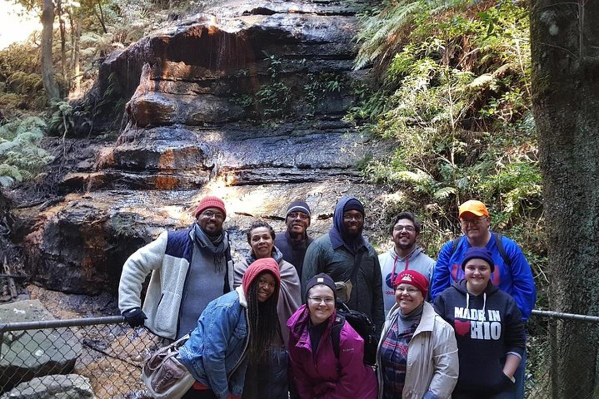 un gruppo di persone in posa per una foto davanti a una cascata