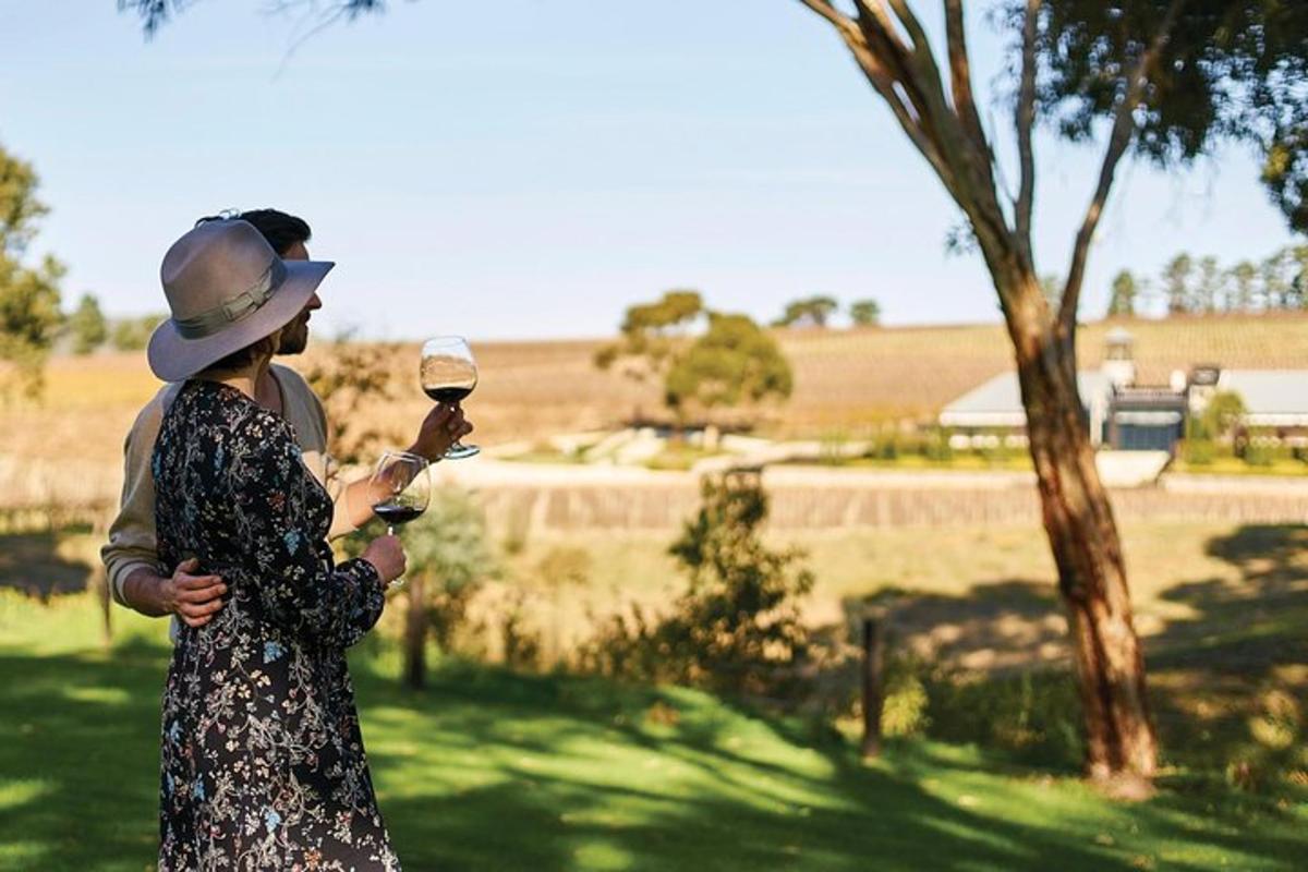 una donna che tiene in mano un bicchiere di vino in un campo