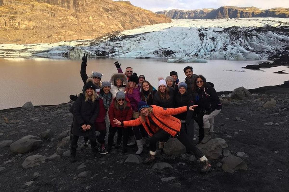 a group of people posing for a picture in front of a glacier