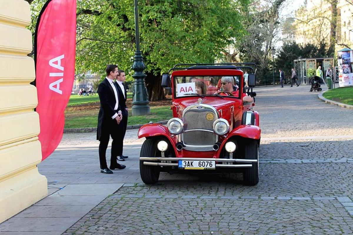 um velho carro vermelho está dirigindo por uma rua