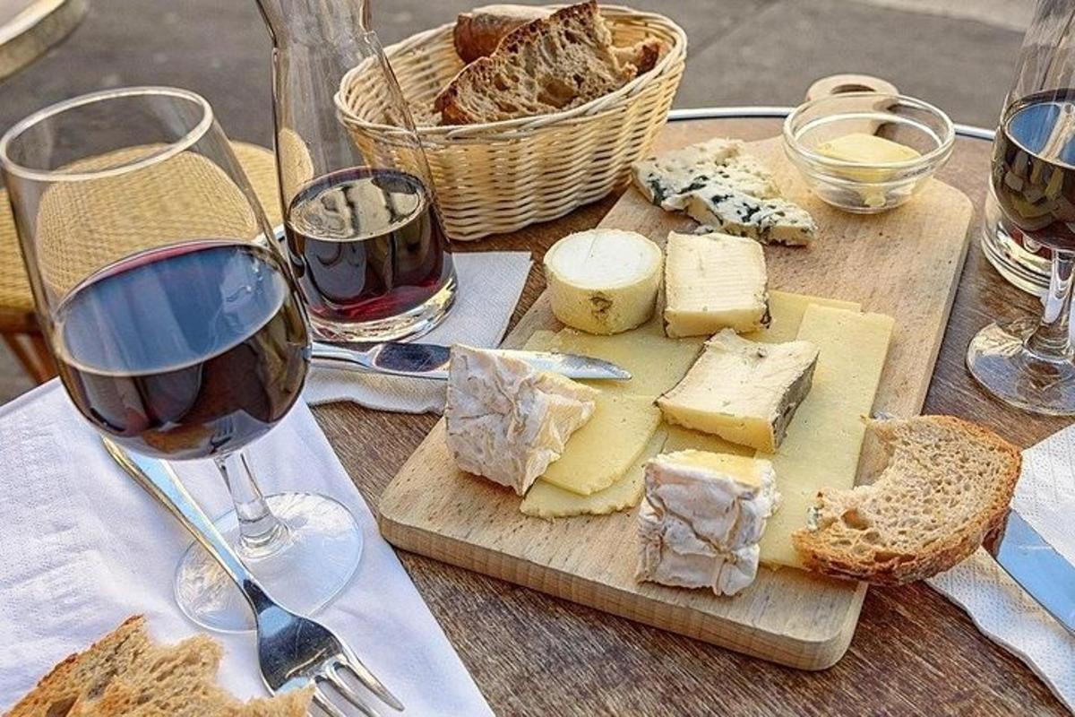 ein Tisch mit Gläsern Wein, Käse und Brot
