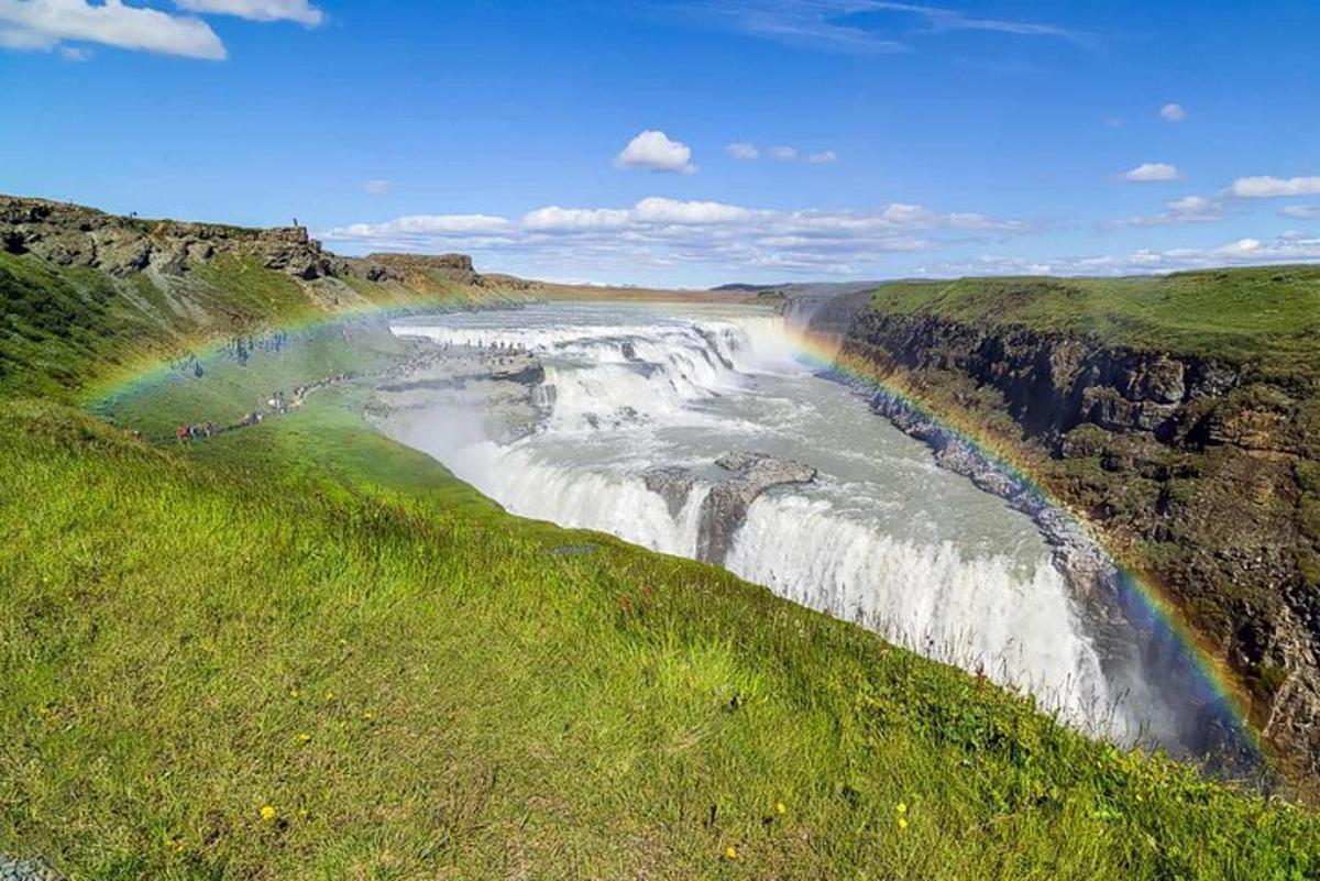 un arcobaleno sopra un fiume con una cascata