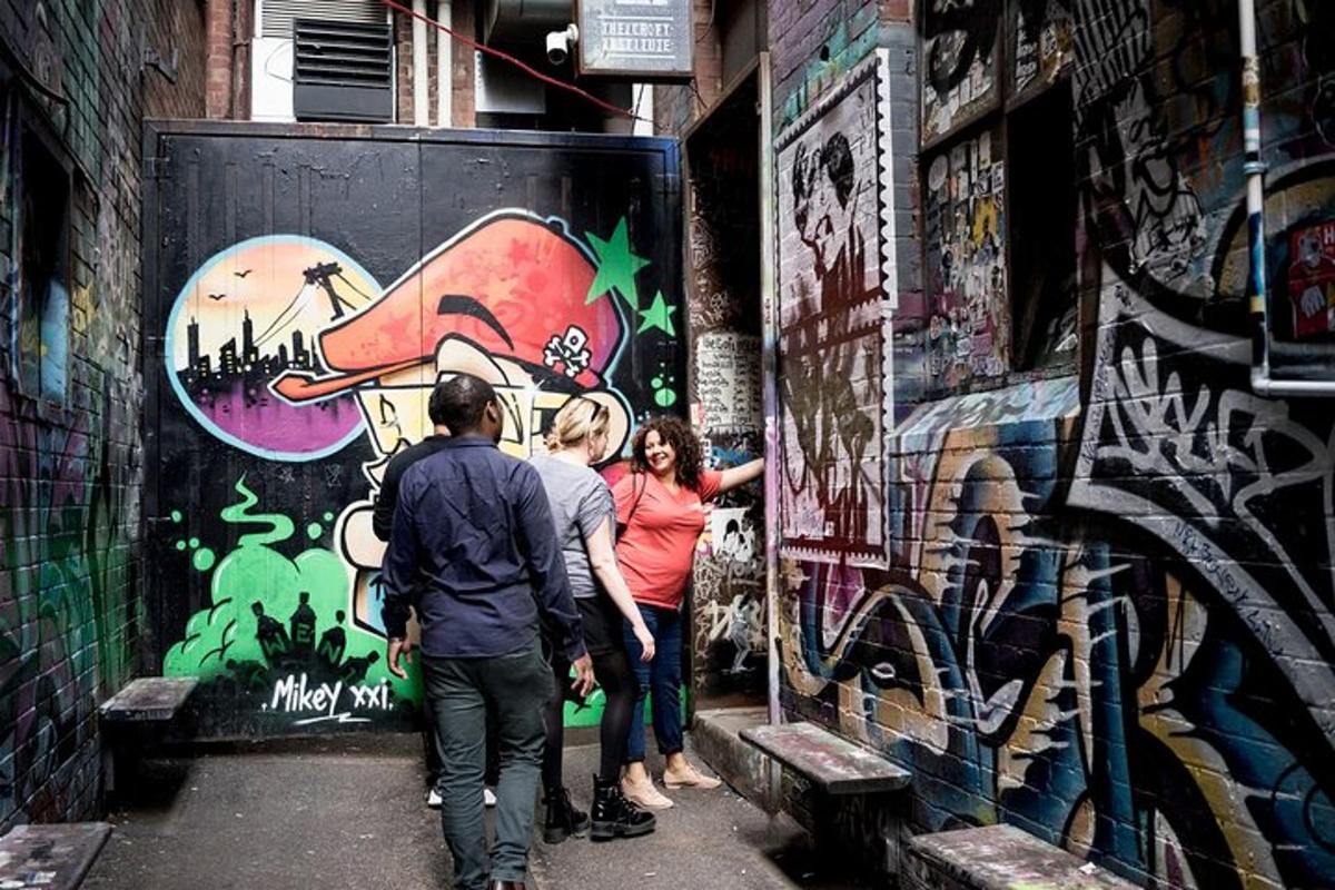 a group of people standing in front of a wall with graffiti