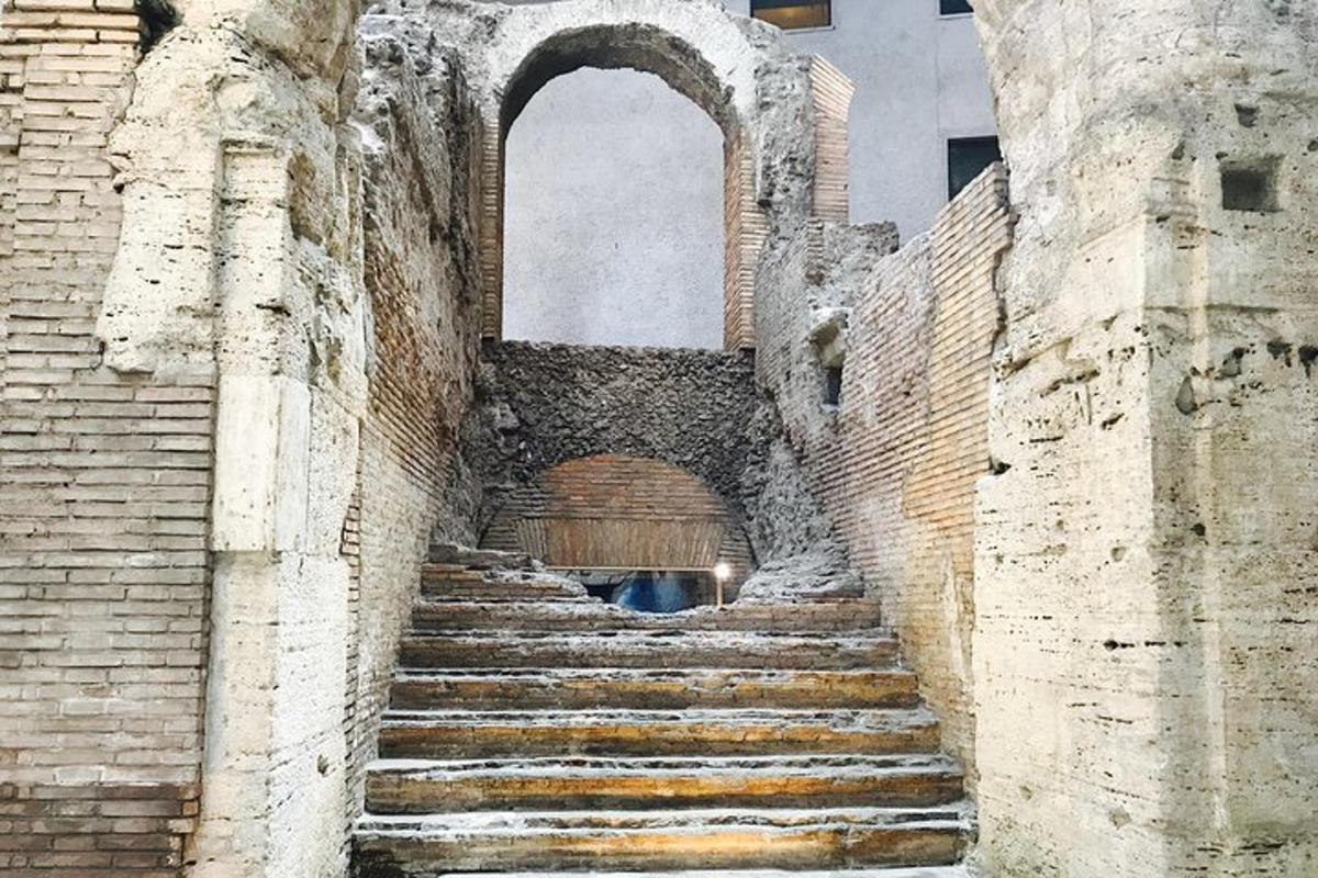 an old brick building with stairs and an arch