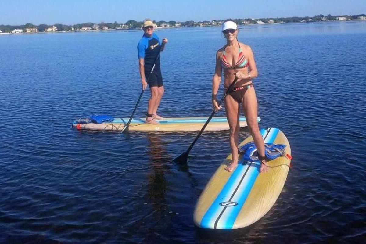 muž a žena na paddleboardu ve vodě