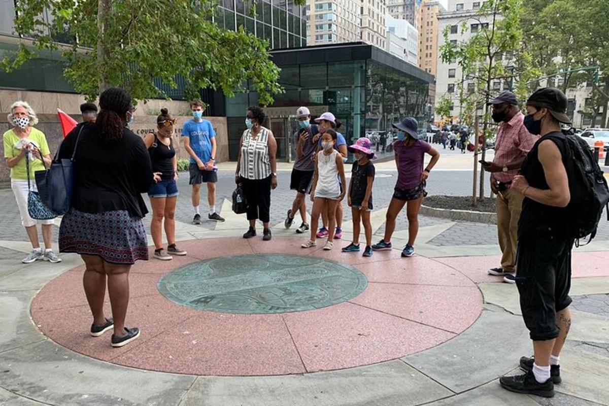 a group of people standing around a manhole in a city