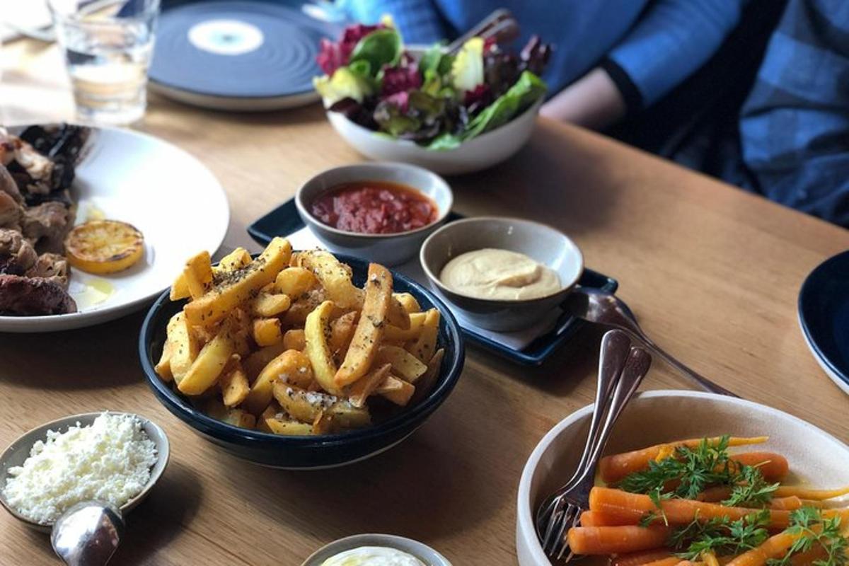una mesa con platos de comida y tazones de papas fritas