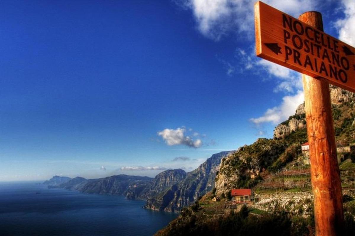 un cartello in cima a una montagna che domina un lago