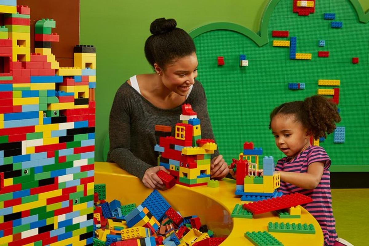 a woman and a child playing with legos