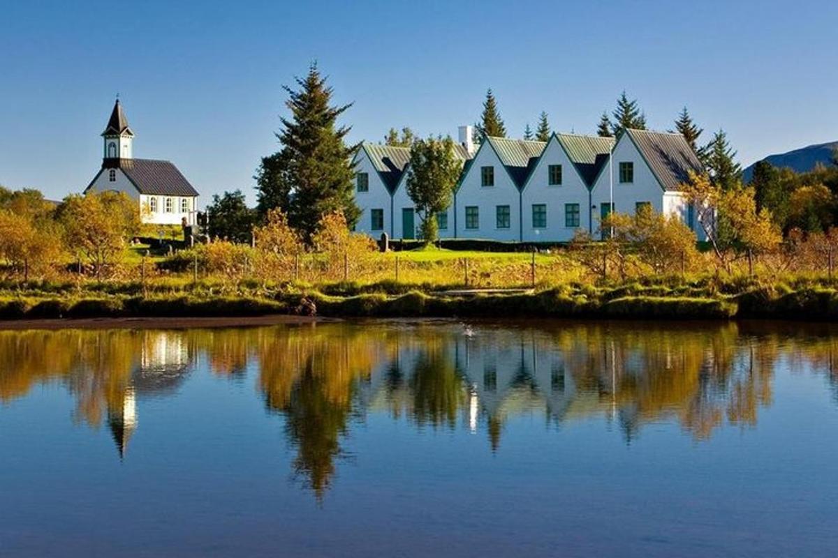 a large white house next to a body of water