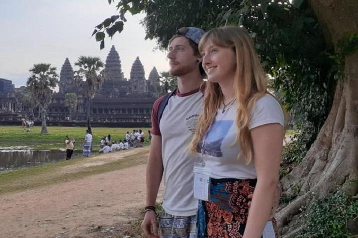 Un hombre y una mujer de pie frente a un templo.