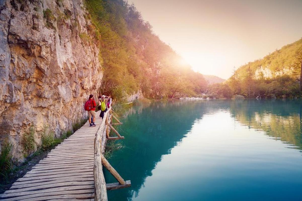 a group of people walking on a bridge over a river