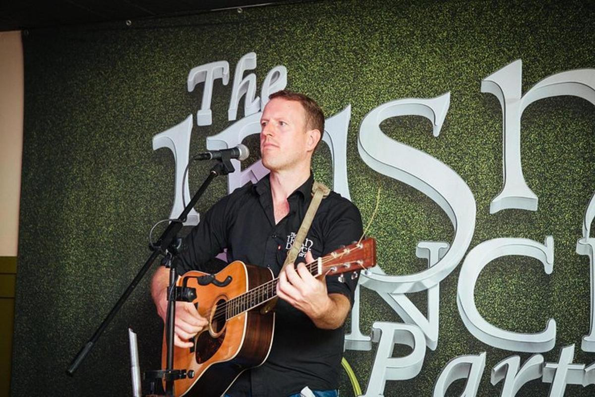a man playing a guitar in front of a microphone