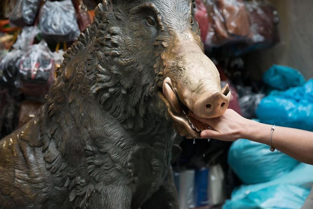 osoba krmící sochu medvěda