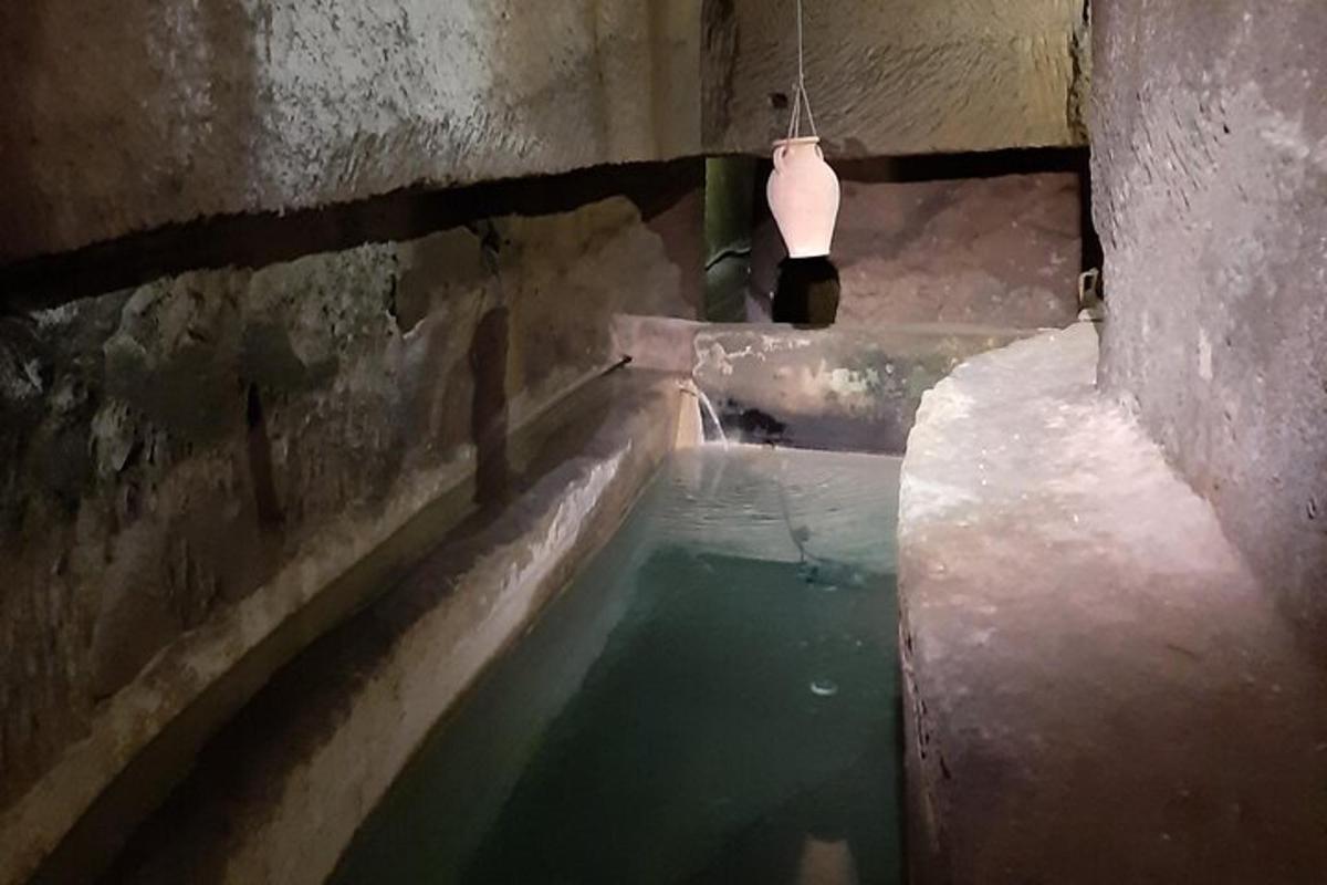 a pool of water in a tunnel with a light