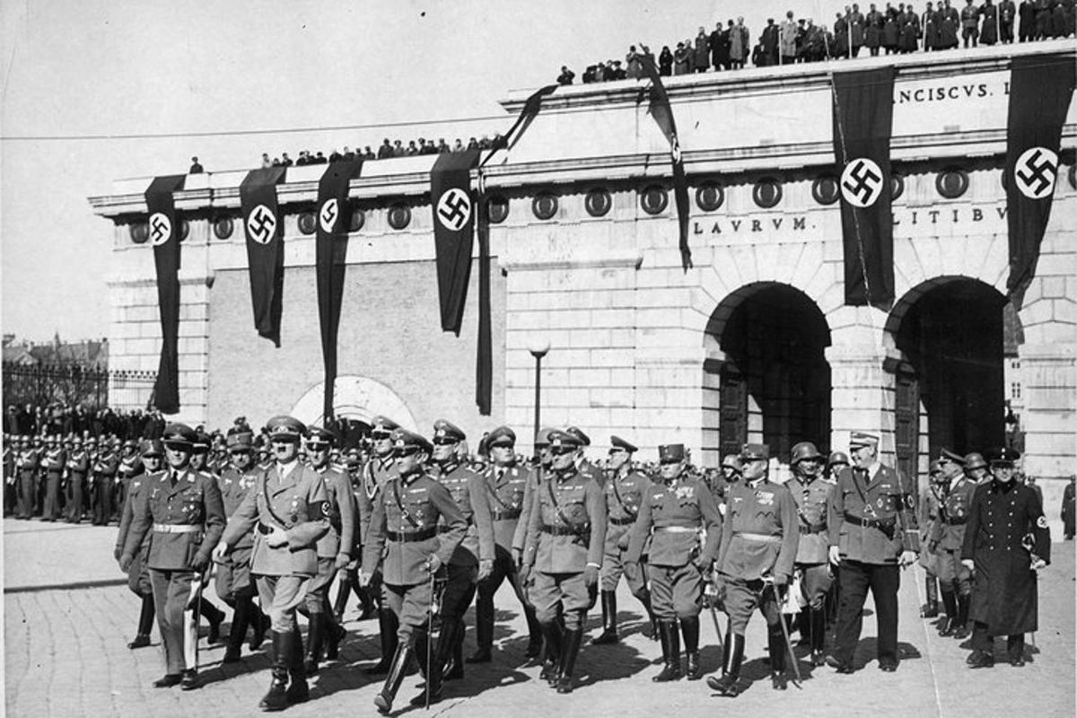 μια ομάδα στρατιωτών που παρελαύνουν μπροστά από ένα κτίριο