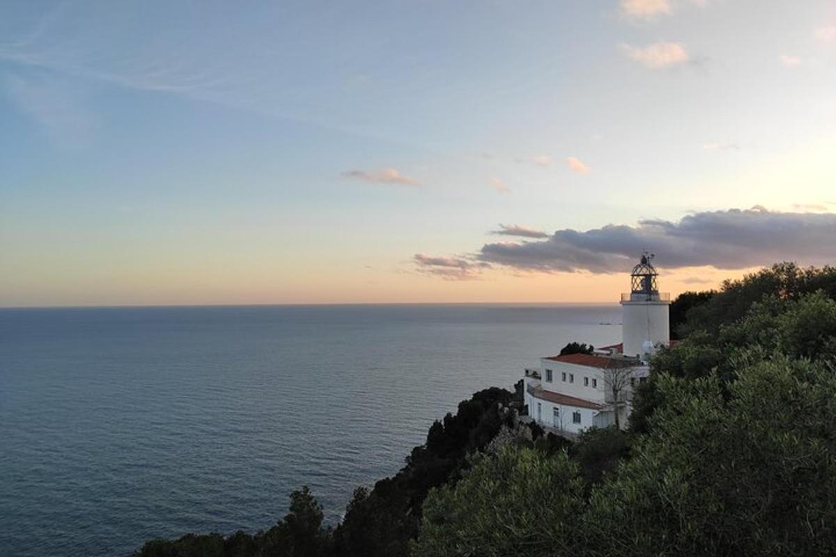 um farol situado no topo de uma colina perto do oceano