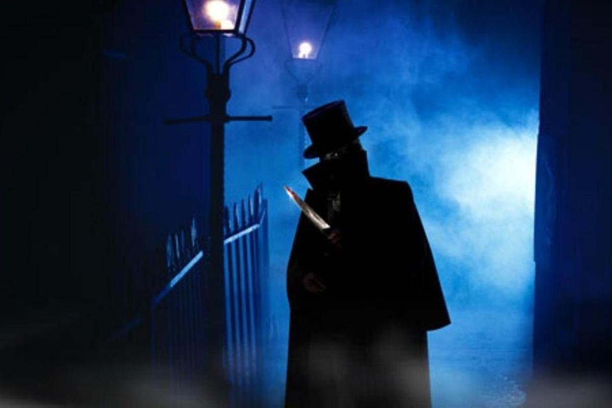 a man in a top hat standing next to a street light