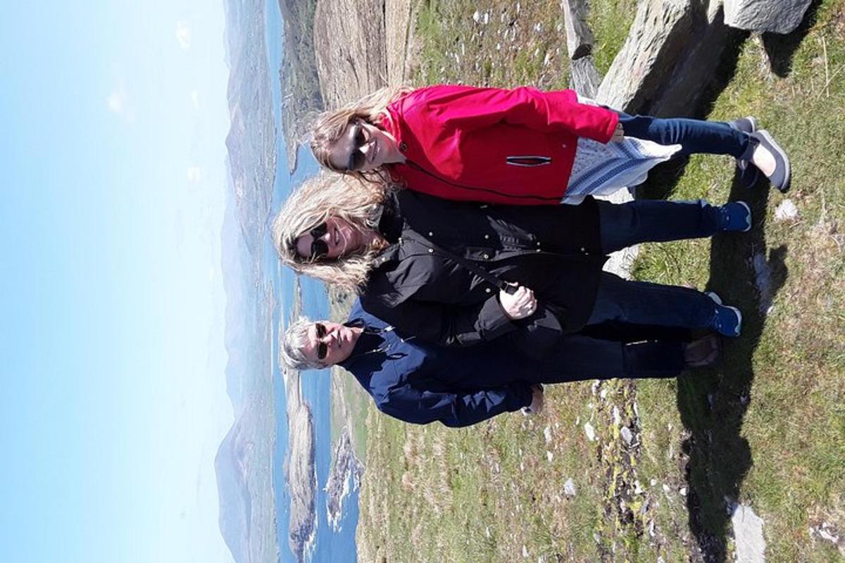 Þrír menn standa á steini við vatnið