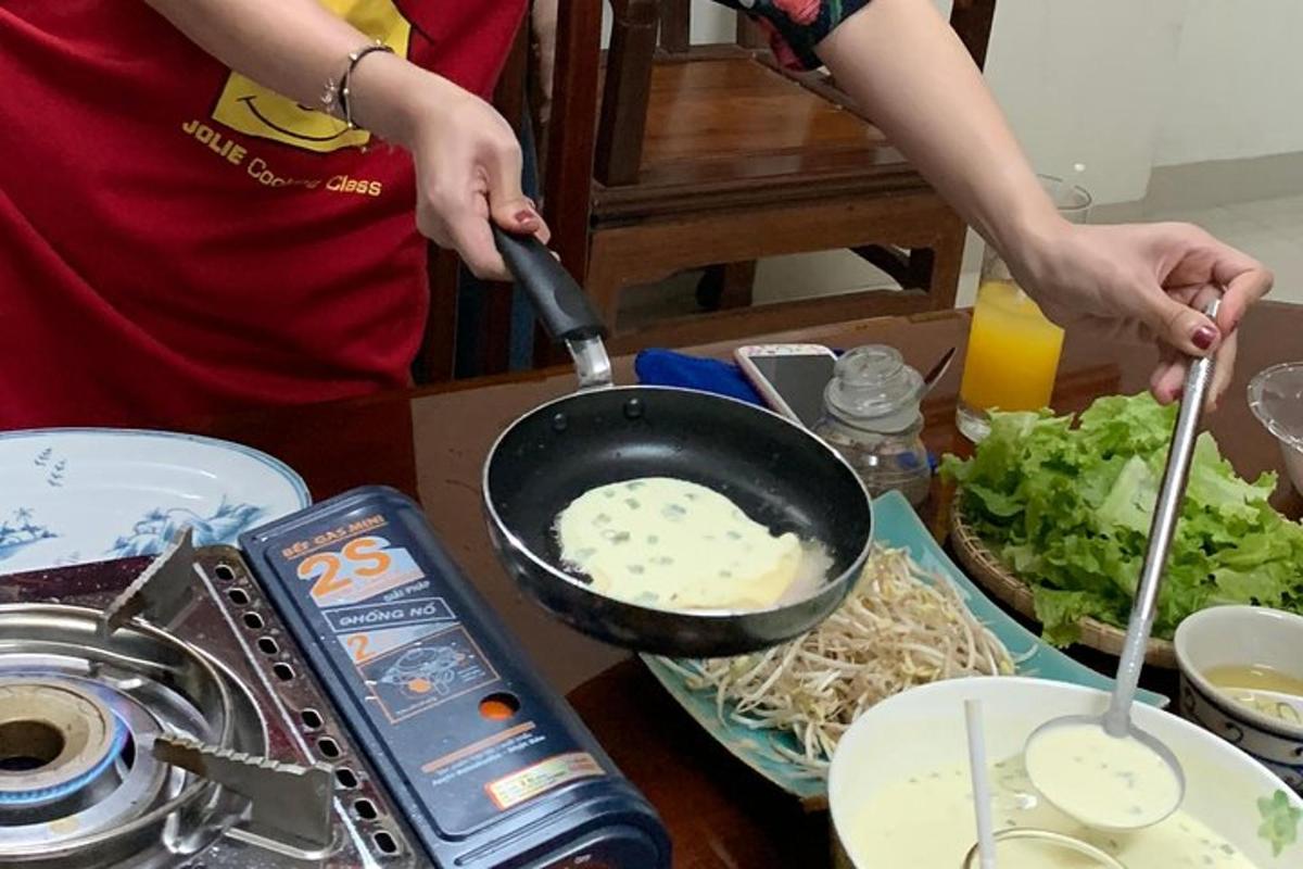 cilvēks, kas gatavo ēdienu pannā uz galda