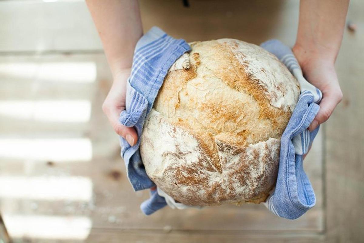 una persona che tiene in mano una persona che tiene in mano una pagnotta di pane