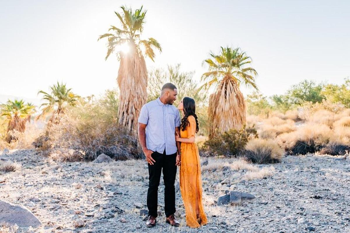 un uomo e una donna in piedi nel deserto con le palme