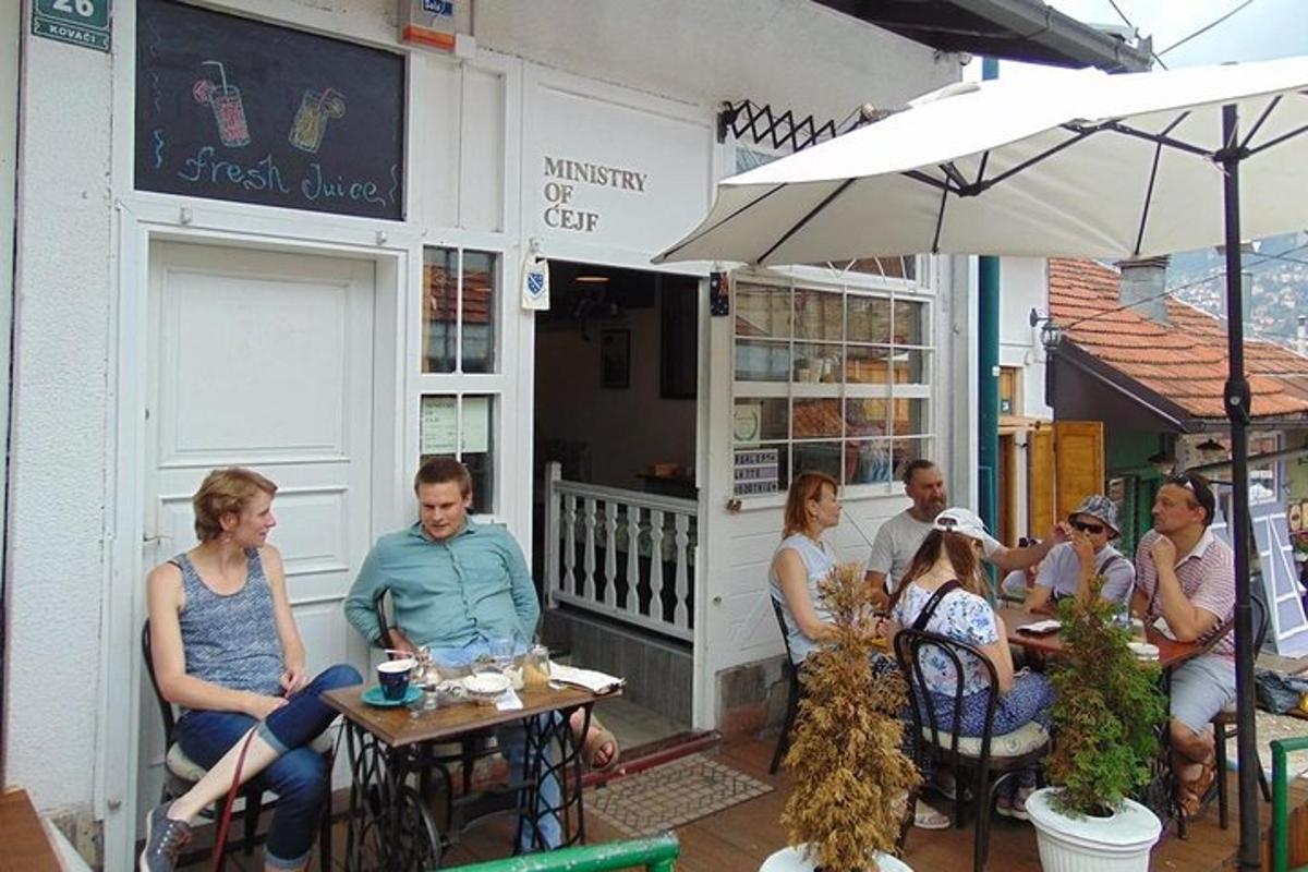 grupa ludzi siedząca przy stolikach przed restauracją