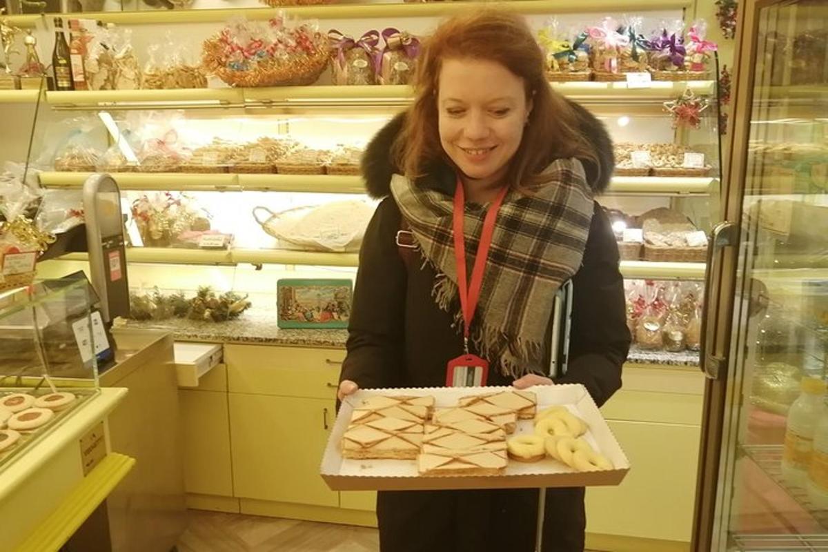 kona heldur á kassa af smákökum í búð