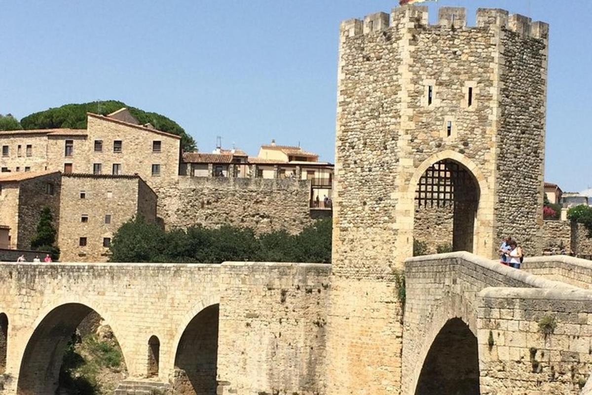 un antic pont de pedra amb un castell al fons