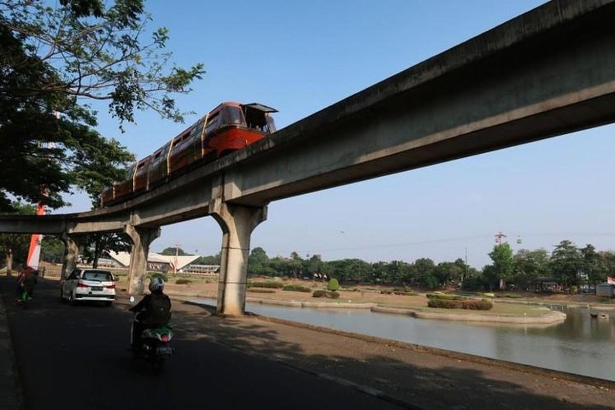 Un tren en un puente con una persona en una motocicleta