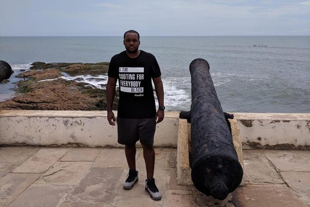 Un hombre de pie junto a un cañón junto al océano.