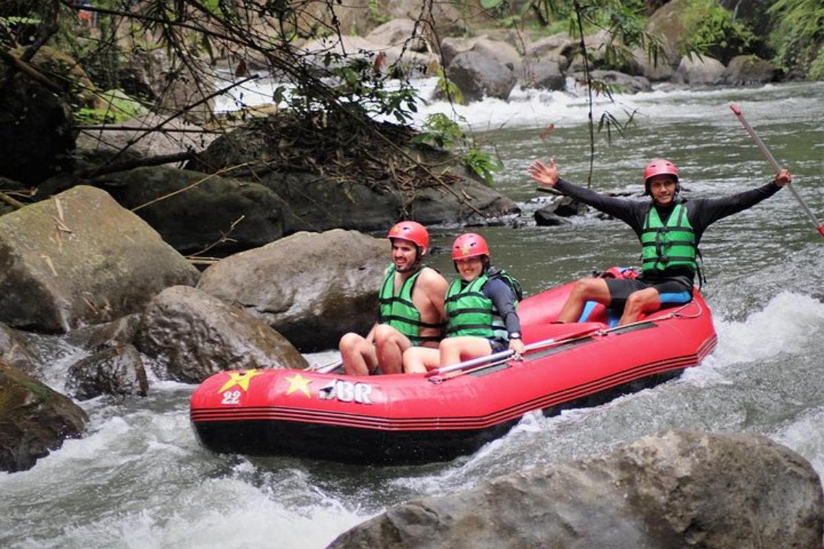 tres personas en una balsa roja en un río