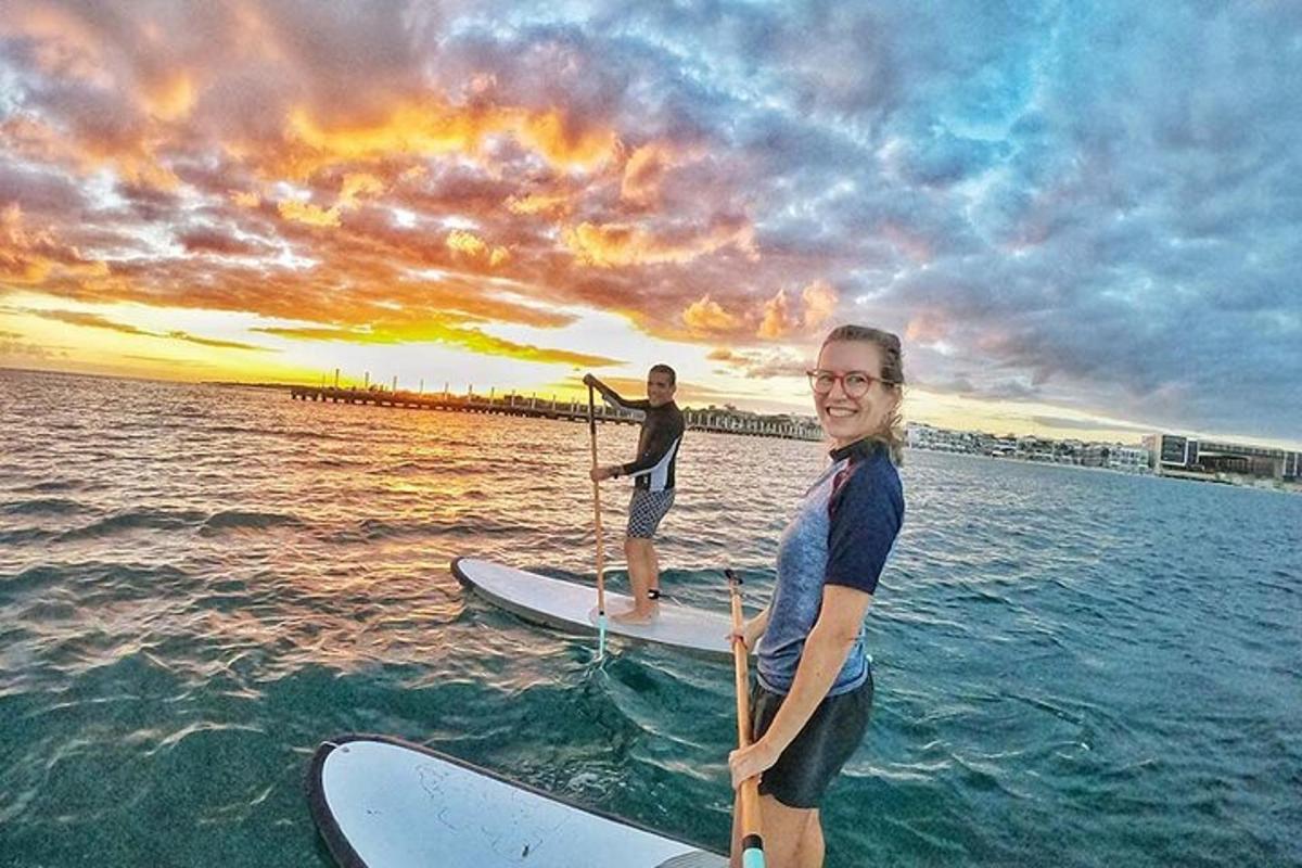 two people are standing on surfboards in the water