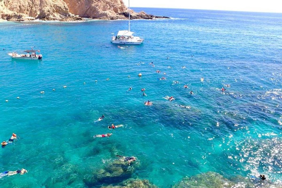 skupina lidí plave v oceánu s lodí