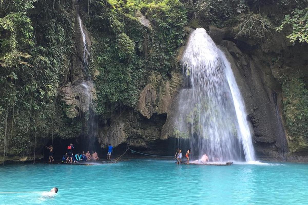 sekumpulan orang di dalam air berhampiran air terjun