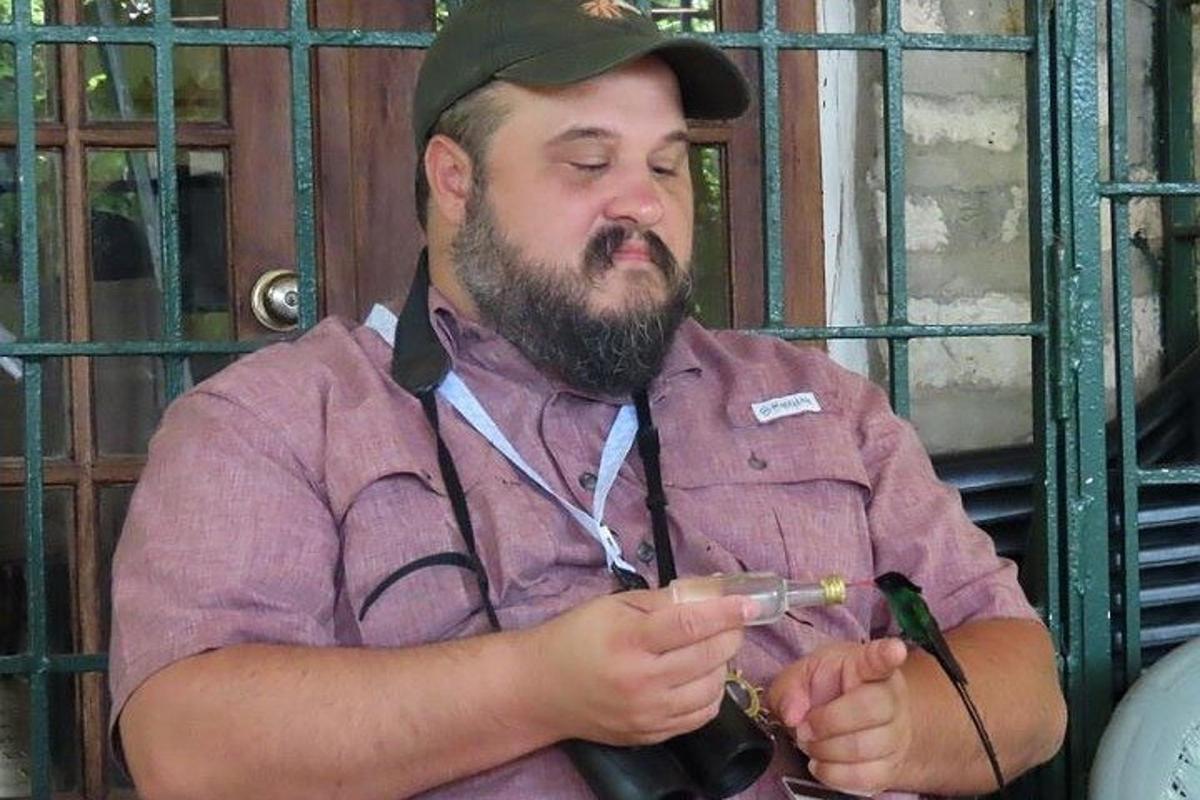 vīrietis ar bārdu smēķē cigareti