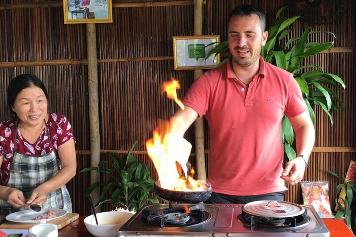 un home i una dona drets al costat d'una graella amb foc