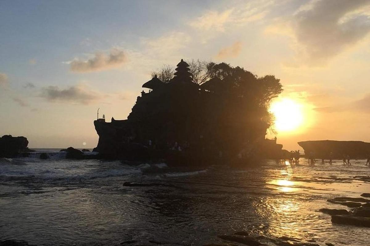 un'isola nell'acqua con il tramonto sullo sfondo