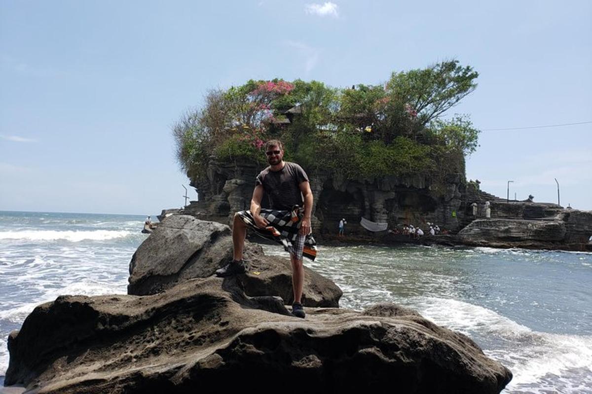 a man sitting on a rock in the ocean