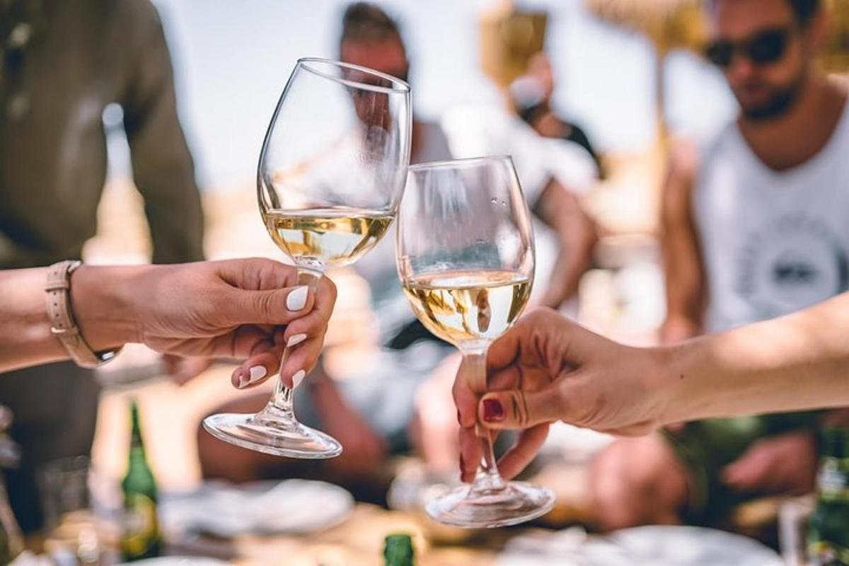 dve osebi držita kozarca belega vina