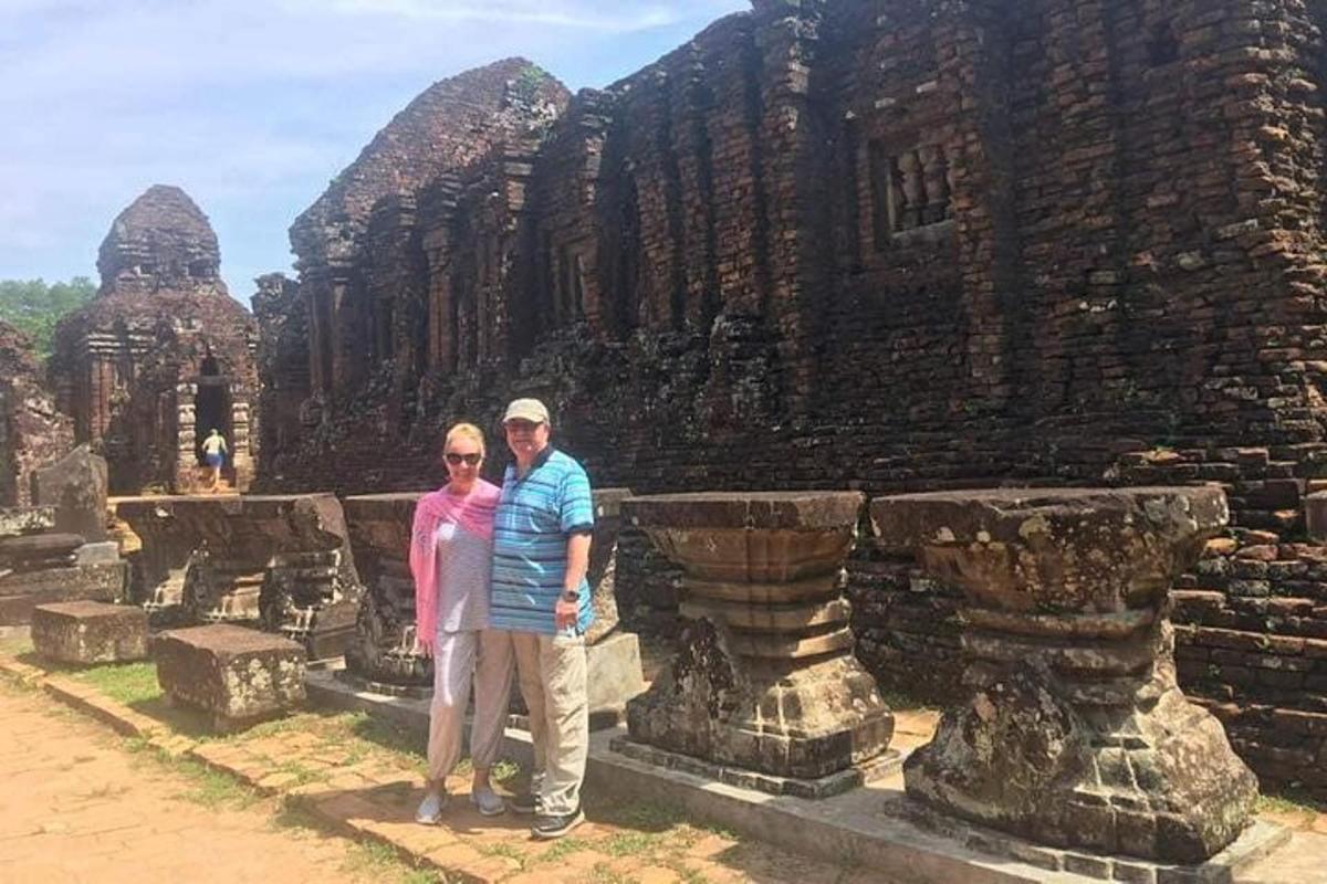 a man and a woman standing in front of a temple