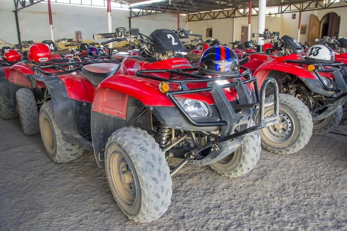 Un grupo de vehículos todo terreno y motocicletas estacionados en un edificio.