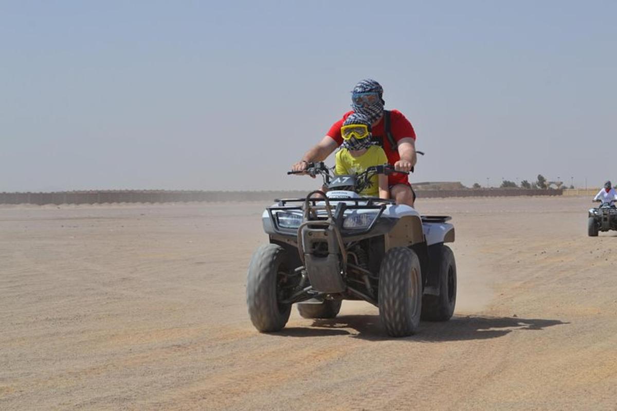 un home muntant un quad al desert