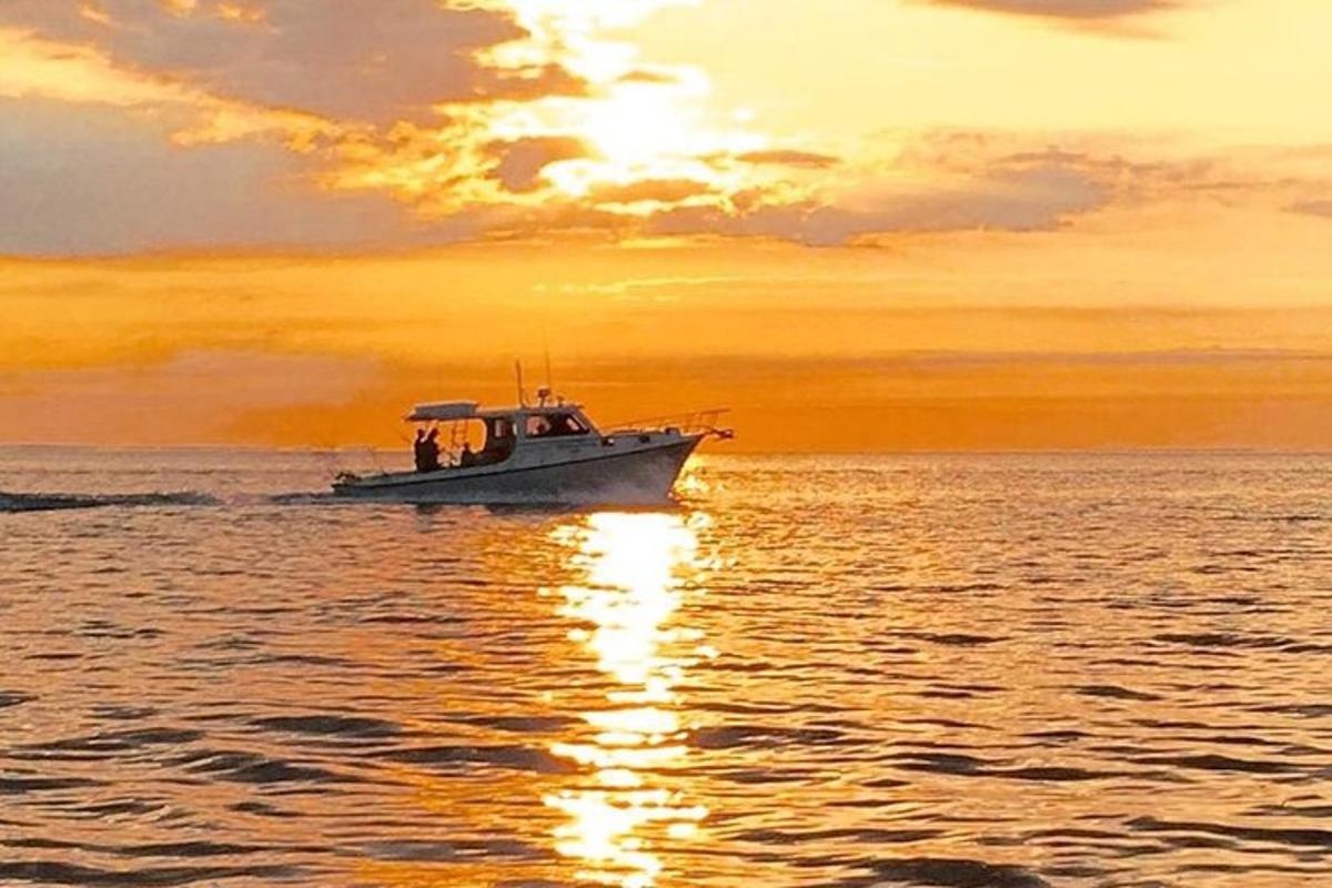 μια βάρκα στο νερό με ένα ηλιοβασίλεμα στο φόντο